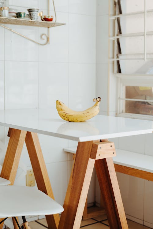 Photo of a Banana on White Wooden Kitchen Table