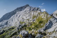 一座岩石山峰与明朗的蓝天和葱郁的绿草构成了一幅令人惊叹的景象