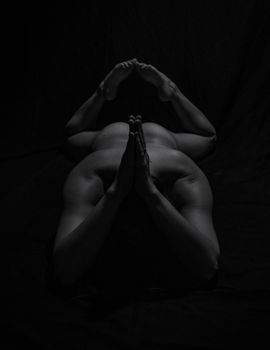 An artistic black and white photo of a woman posing in yoga, highlighting strength and form.