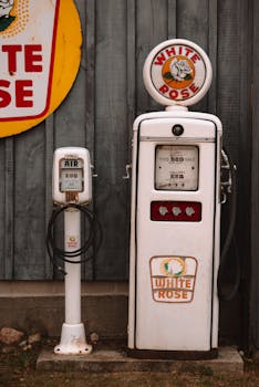 Classic White Rose gas pump and air station against a wooden wall, vintage feel.