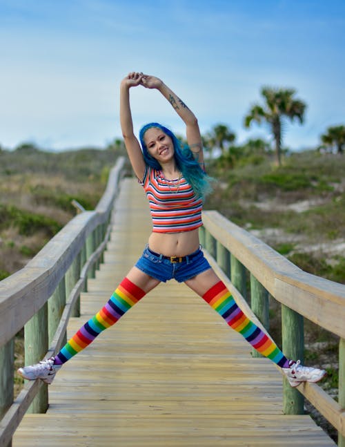 A Woman in a Colorful Outfit Stepping on a Wooden Railing