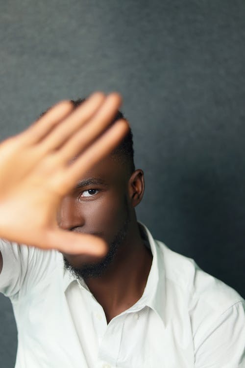 A Man in White Shirt Covering His Face