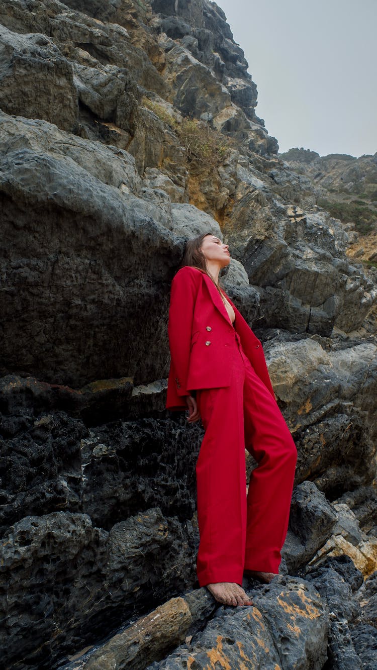 A Person In Red Suit Standing On Rocks
