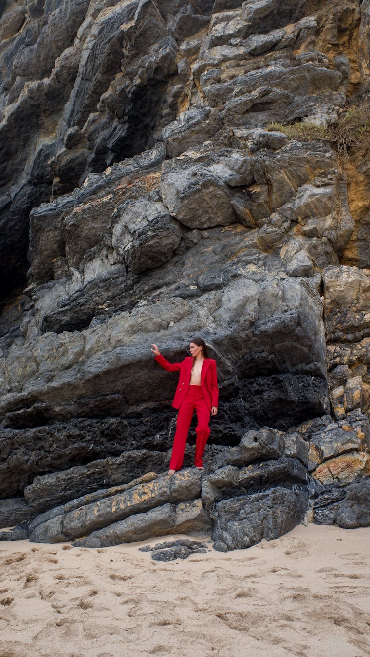 A Person In Red Suit Standing On Rocks
