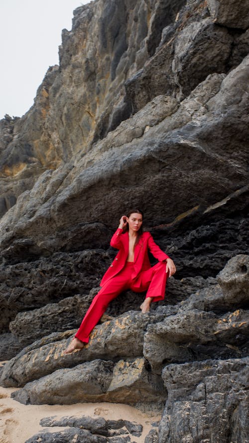 Woman in a Red Blazer and Red Pants on a Rocky Cliff 