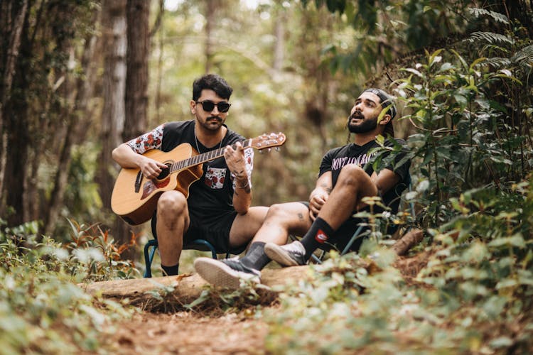 Men Playing Guitar And Singing In The Forest