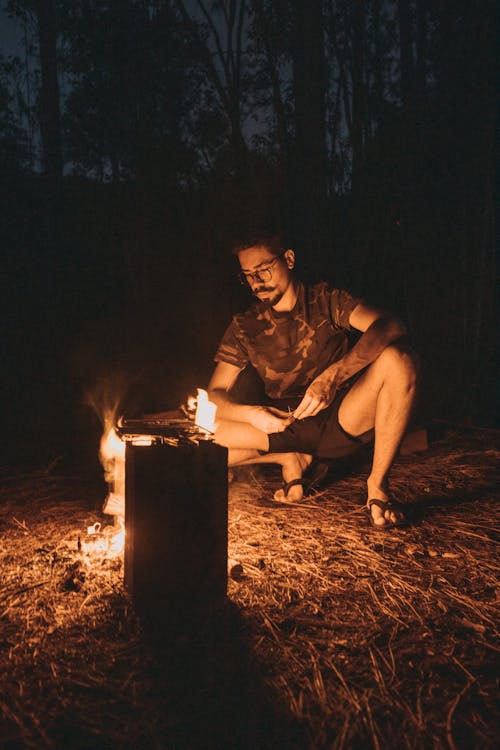 Man Lighting a Fire in the Forest 