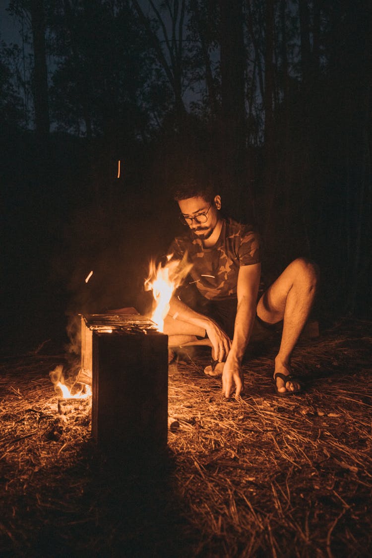 A Man Sitting Near A Fire