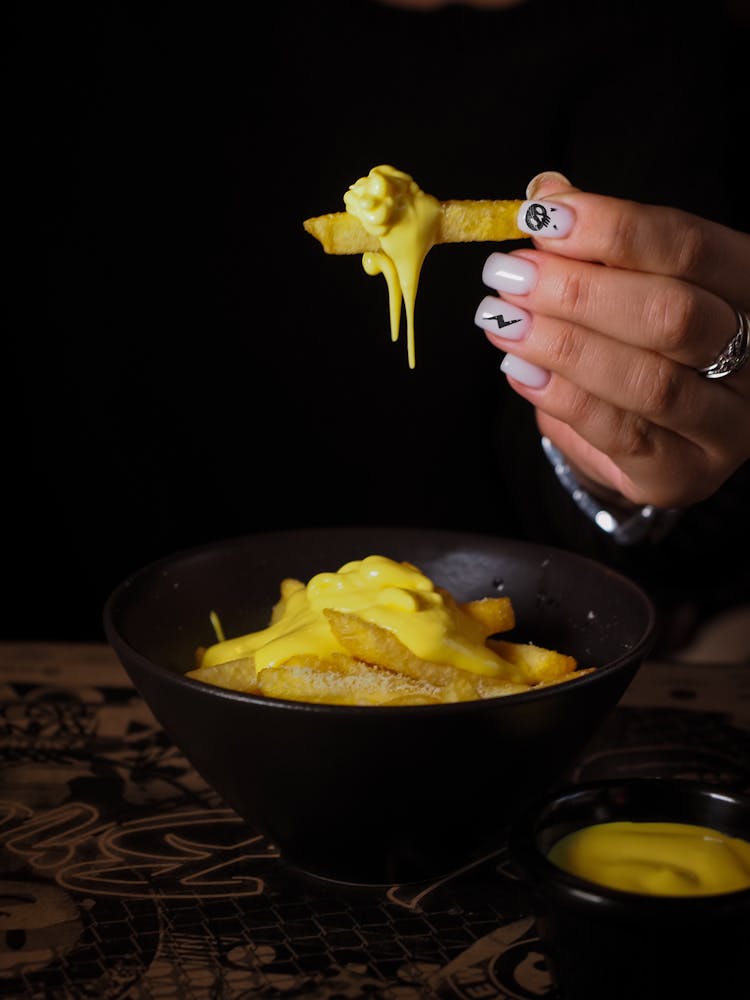 Woman Eating French Fries With Sauce