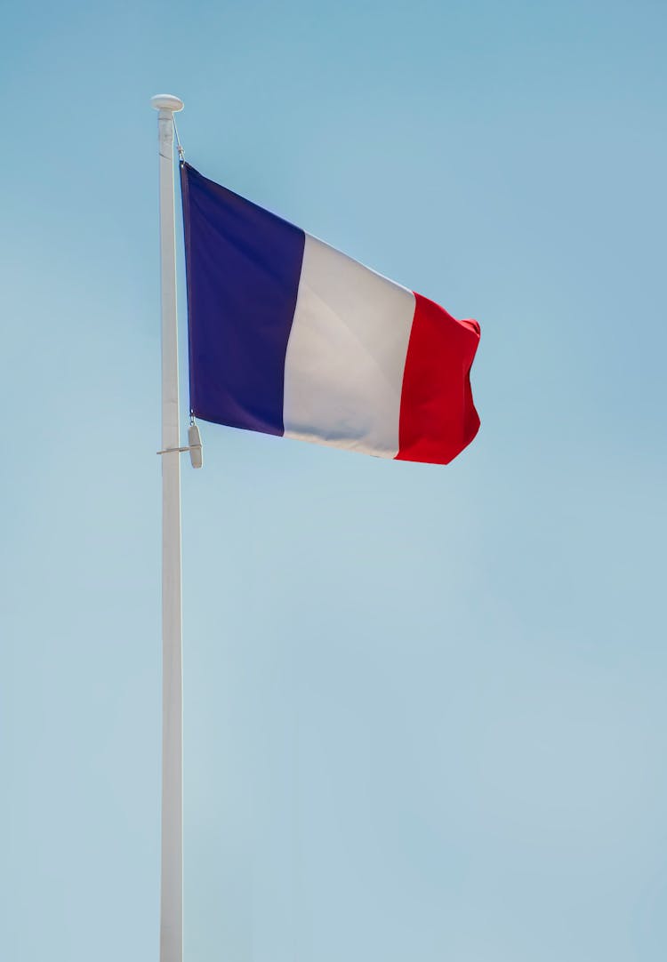 The Flag Of France On White Pole Under Blue Sky