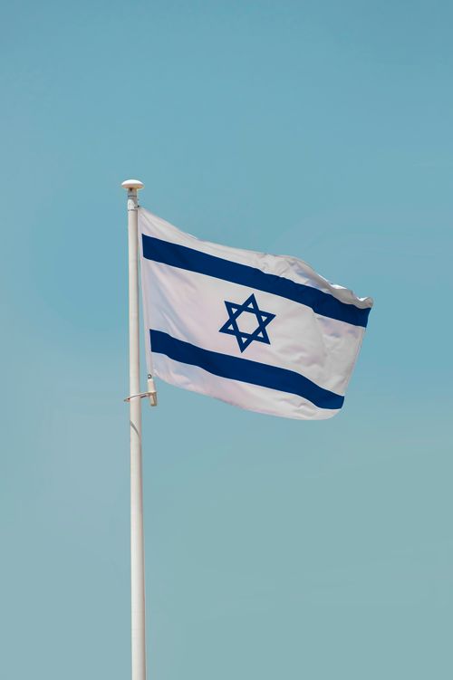 Free Picture of the Israeli flag waving against a clear blue sky in Jerusalem, Israel. Stock Photo