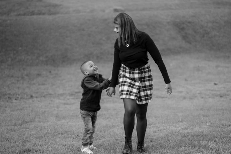 Woman With Child Walking In Field