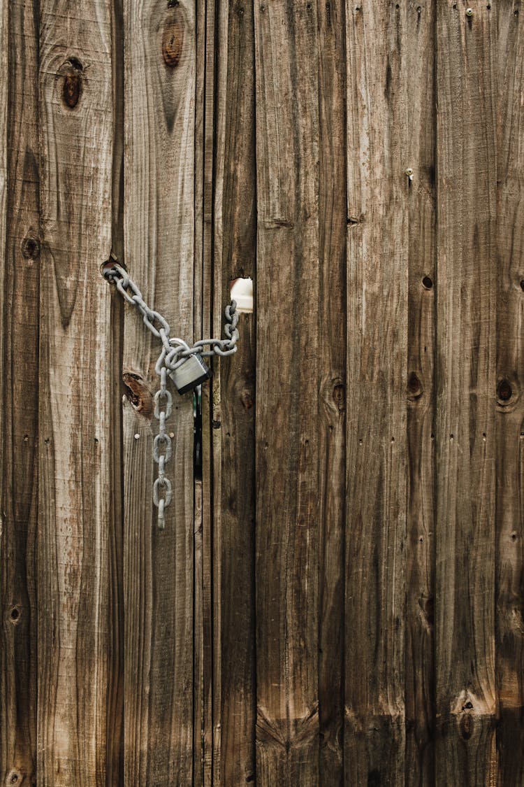 Gray Chain With Padlock On A Wooden Door