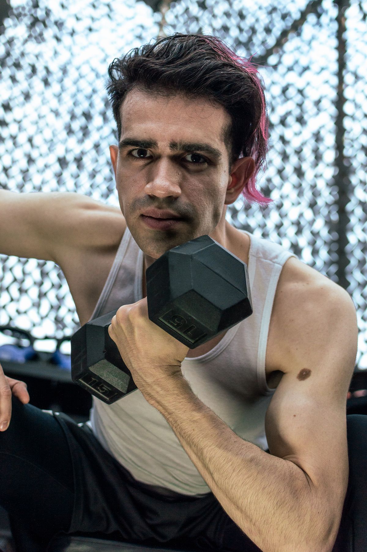 Athlete performing dumbbell strength training in a gym