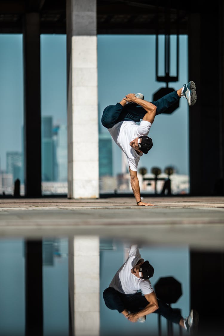 A Man In White Shirt Breakdancing On The Street