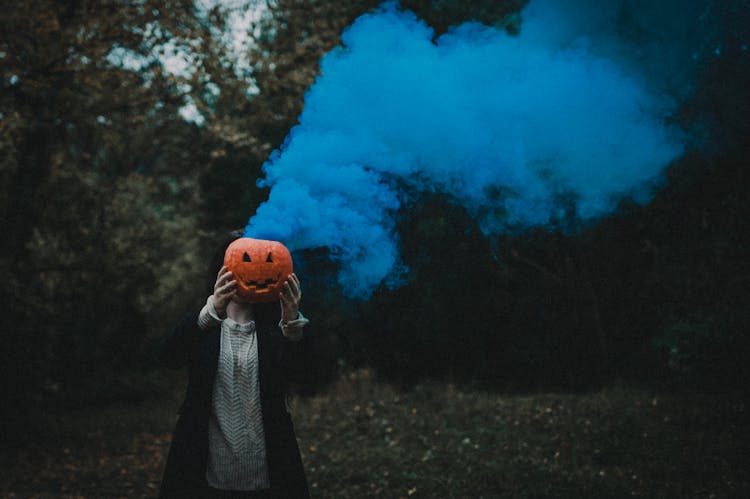 A Person Holding A Carved Pumpkin