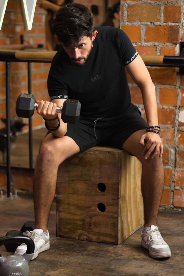 Man In Black Shirt Lifting A Dumbbell