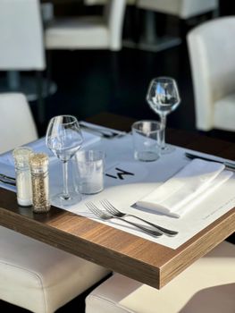 A sophisticated restaurant table setting with cutlery and wineglasses, perfect for a fine dining experience.