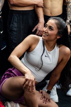 Young woman smiling during an energetic group workout session outdoors.