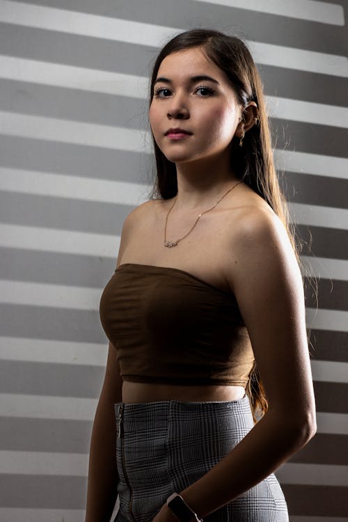 Portrait of a Young Woman in Brown Tube Top and Plaid Skirt 