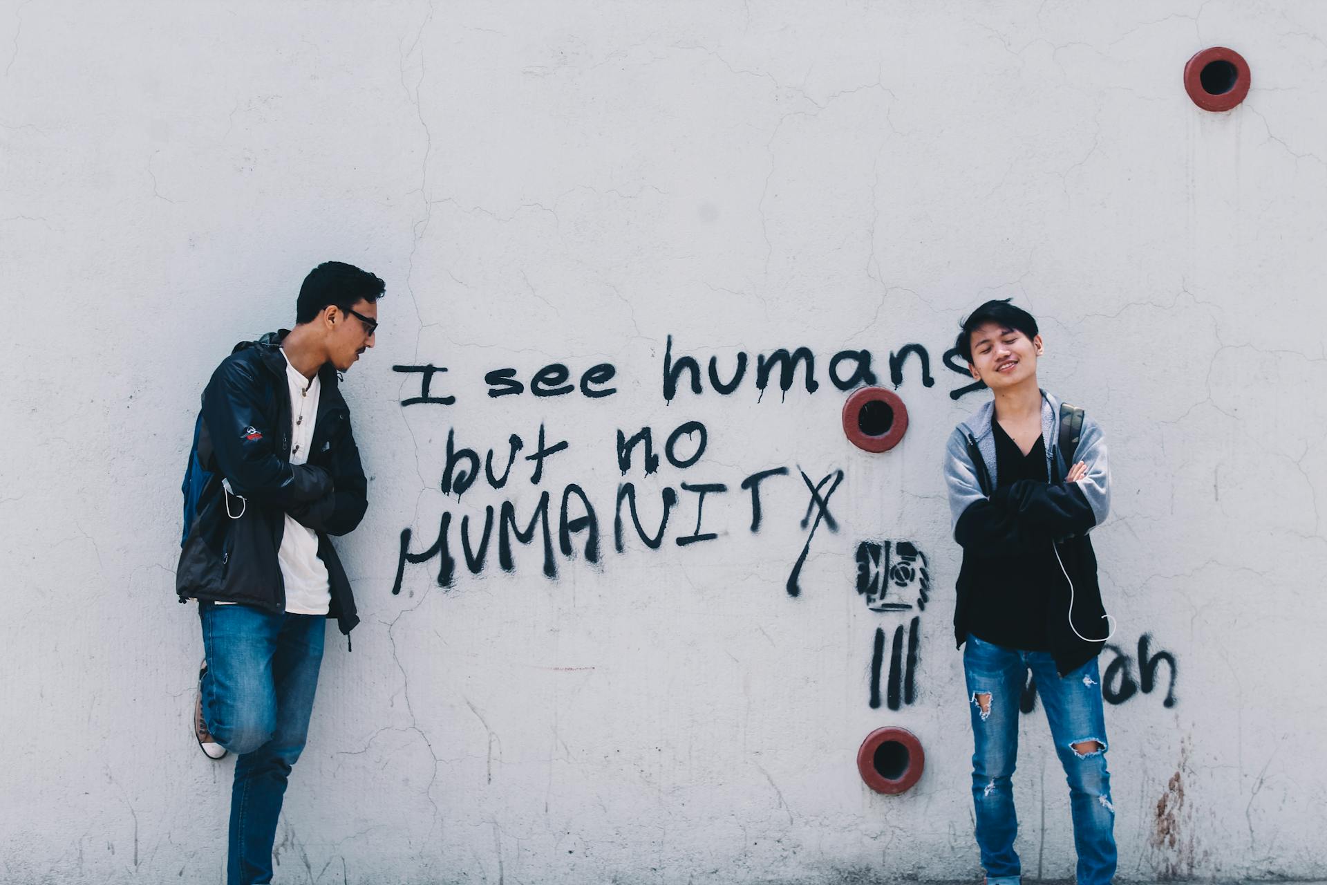 Two Men Standing Beside Painted Wall