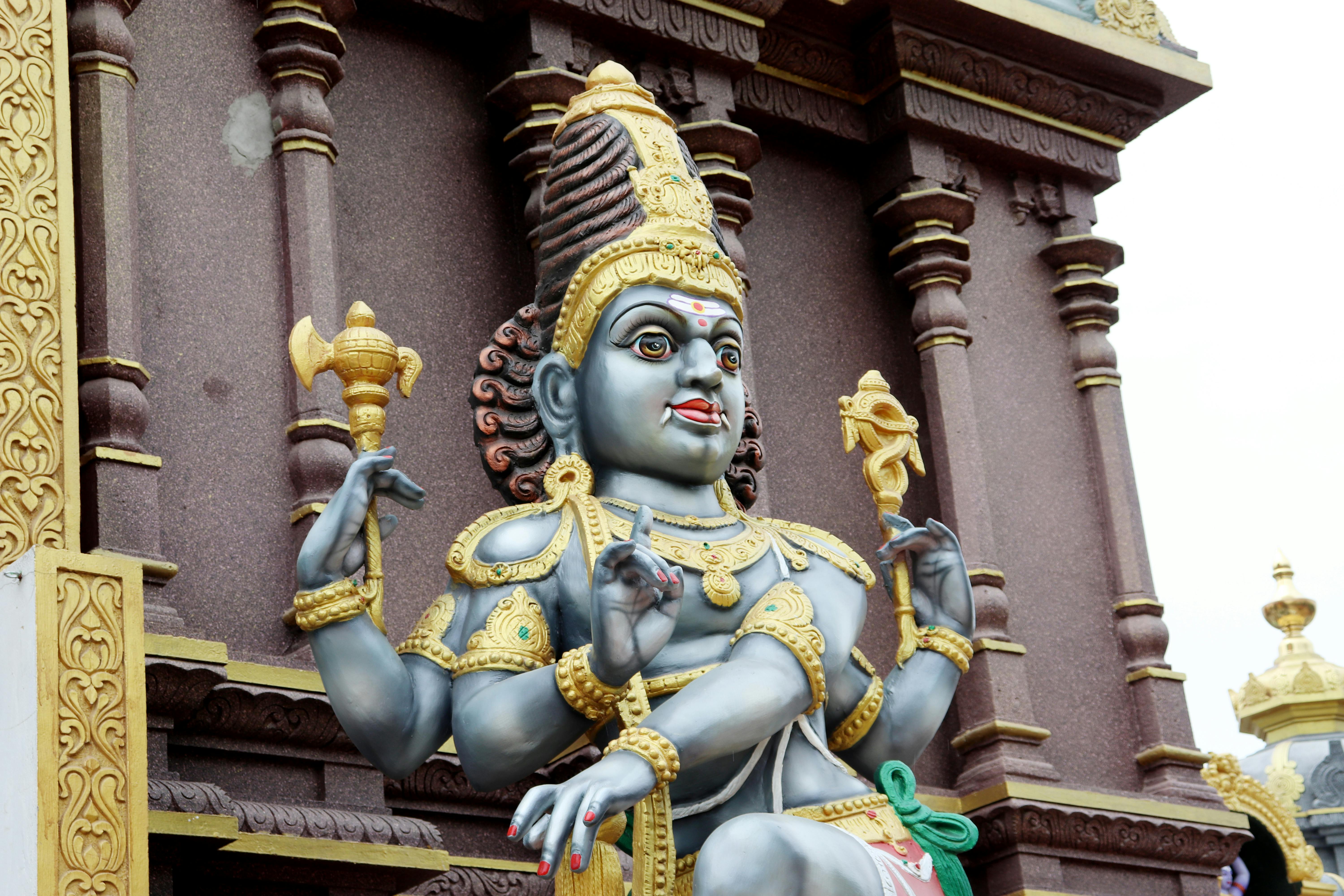 hindu deity statue near brown brick wall