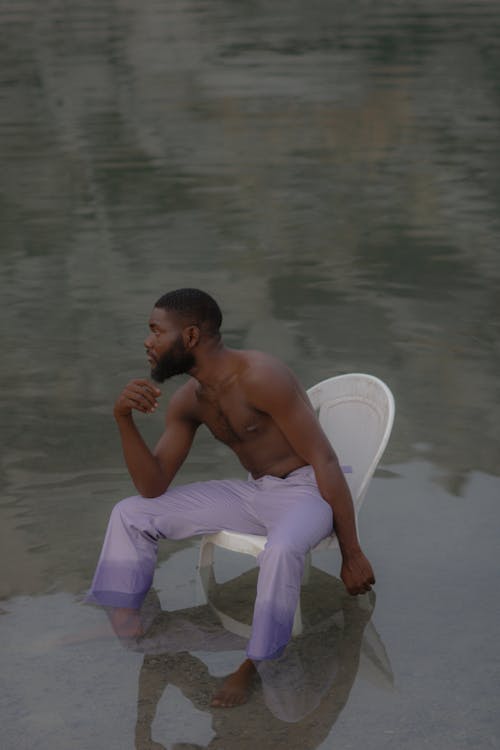 Man Sitting on a Chair in a Lake 