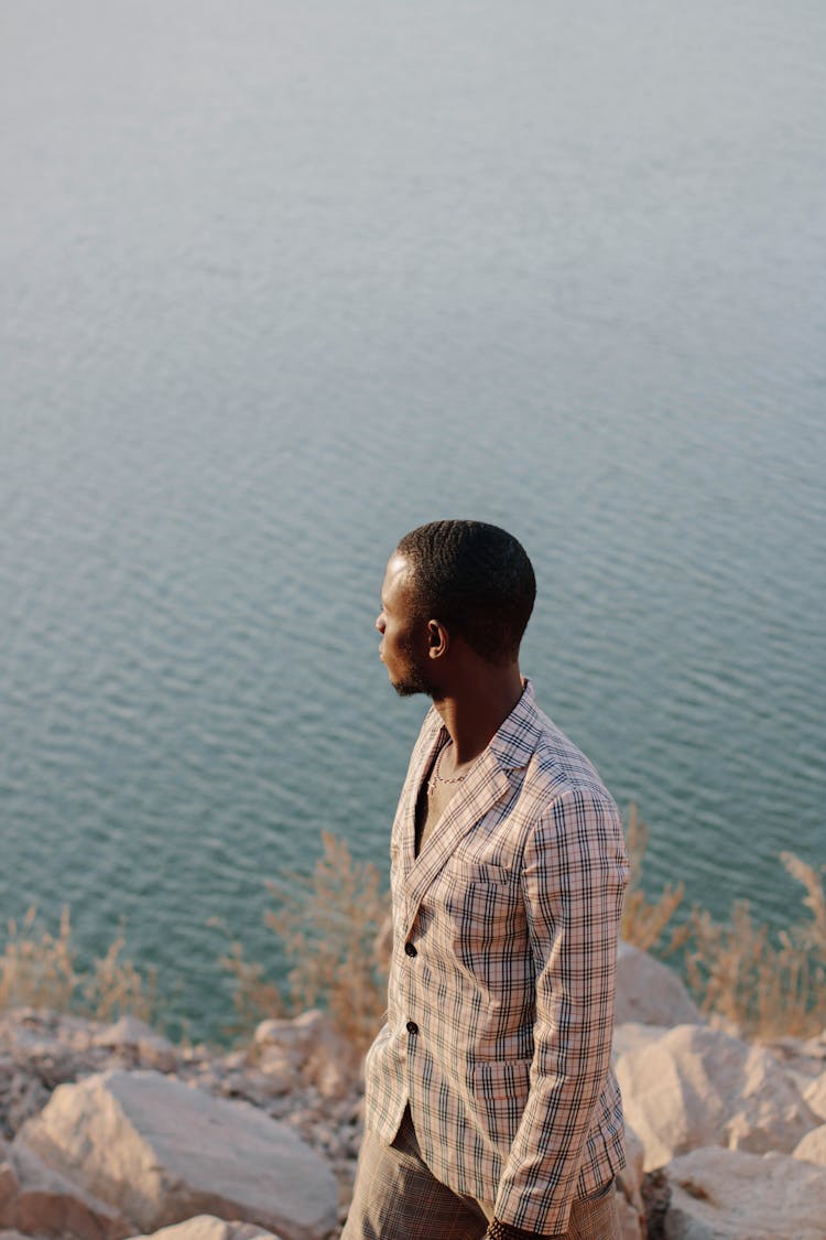 Man In Suit On Rocks Near Sea