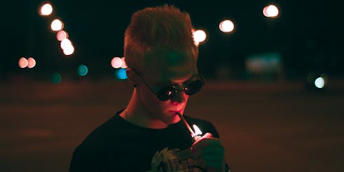 Free Man in Black Shirt Lighting Up Cigarette Stick during Nighttime Stock Photo