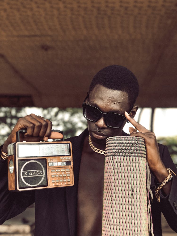 A Man Holding An Old Radio