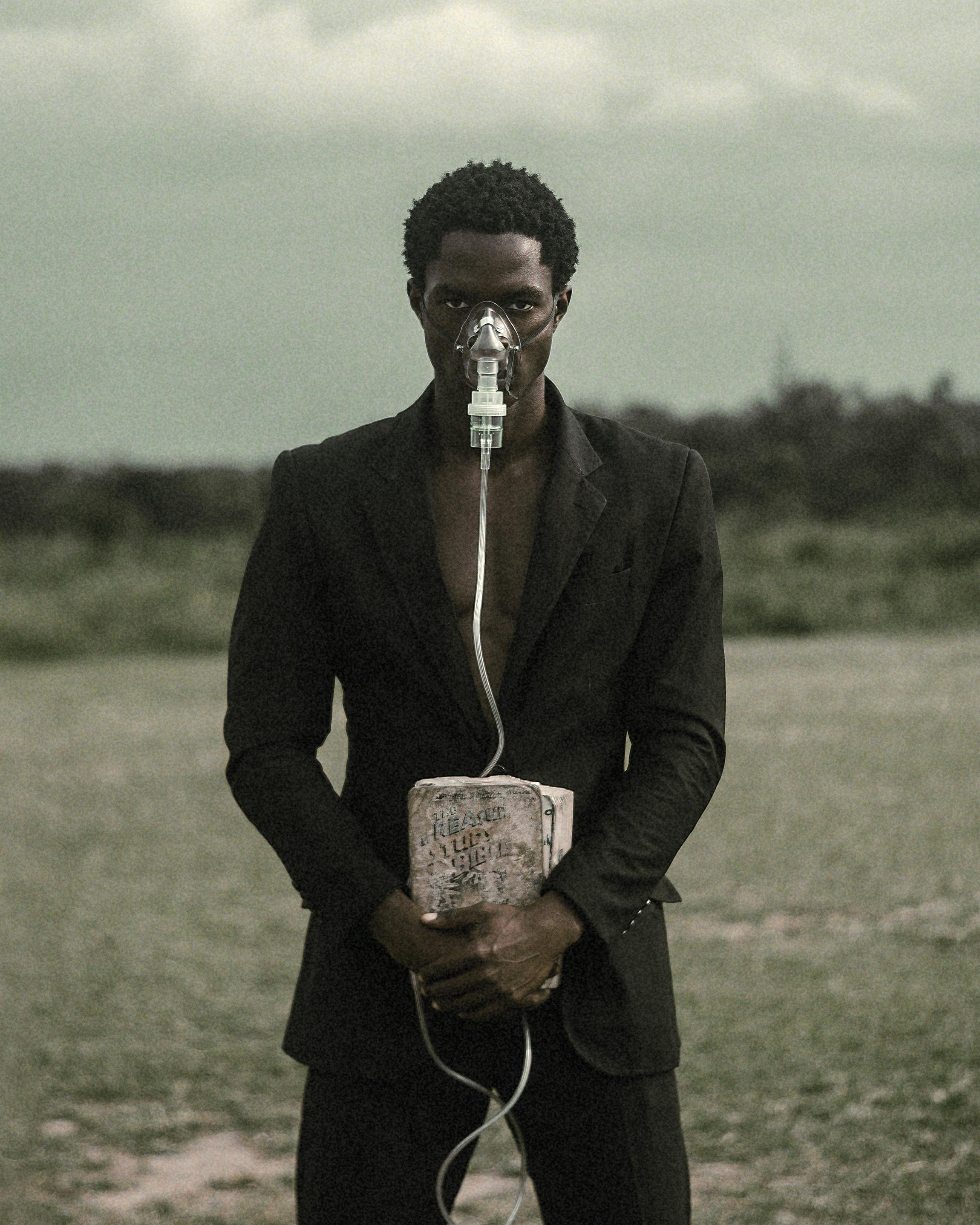 man in suit wearing oxygen mask holding box