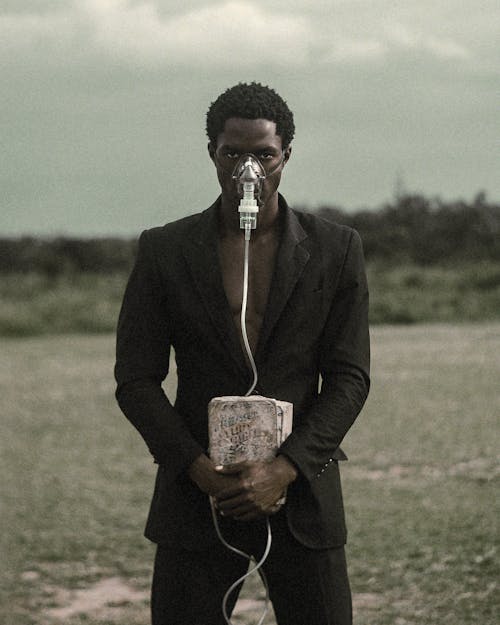 Man in Suit Wearing Oxygen Mask Holding Box