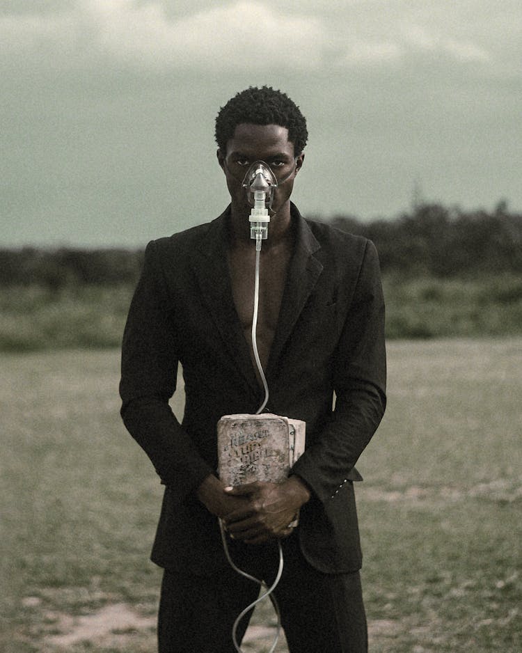 Man In Suit Wearing Oxygen Mask Holding Box