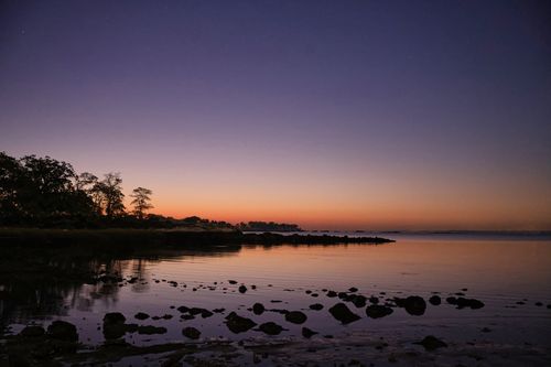 Free Beautiful twilight view of Stamford shoreline reflecting vibrant hues in a calm sea. Stock Photo