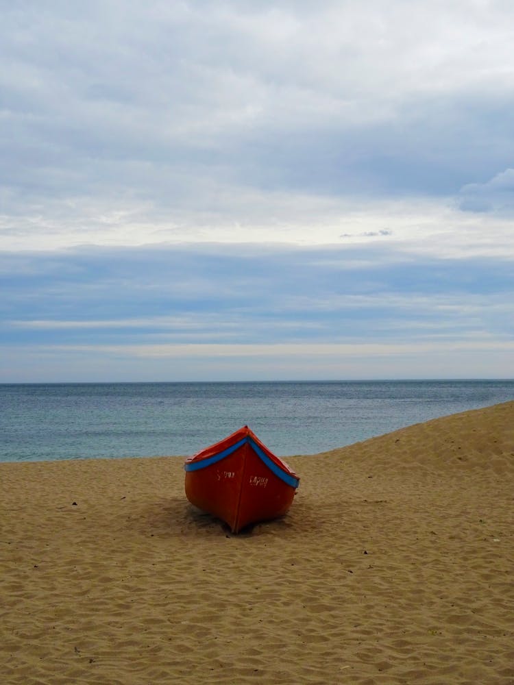 Red Wooden Boat On The Shore