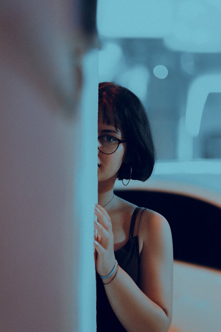 Girl In Glasses Looking Behind Wall