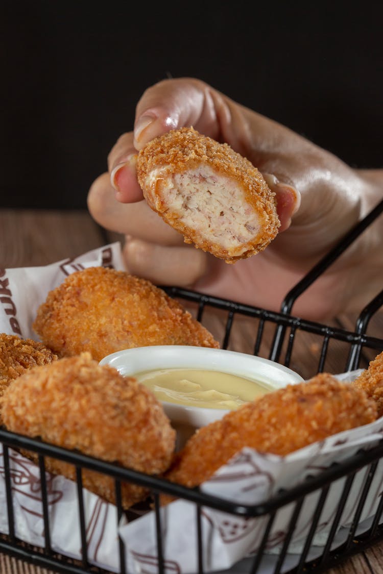 Cloe-up Of Woman Holding A Chicken Nugget 