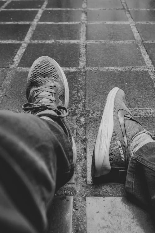 Free Grayscale Photo of a Person Wearing Sneakers  Stock Photo