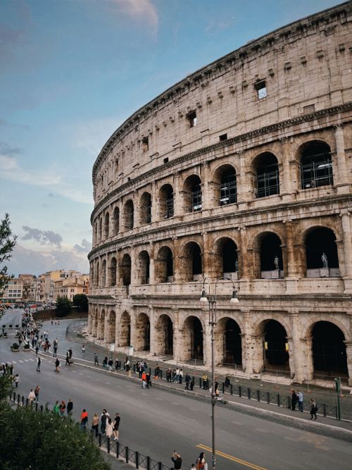 Free Stunning image of the Colosseum in Rome with people walking by at dusk. Stock Photo