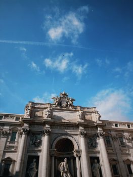 Iconic Trevi Fountain with clear blue sky in Rome, showcasing historic architecture.