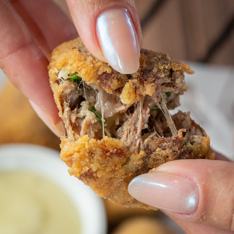 Close-up Of Woman Hands Tearing Chicken Nugget