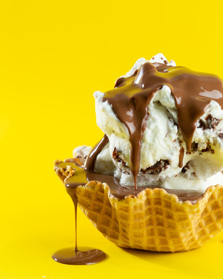 Ice Cream With Chocolate In Waffle On Yellow Background