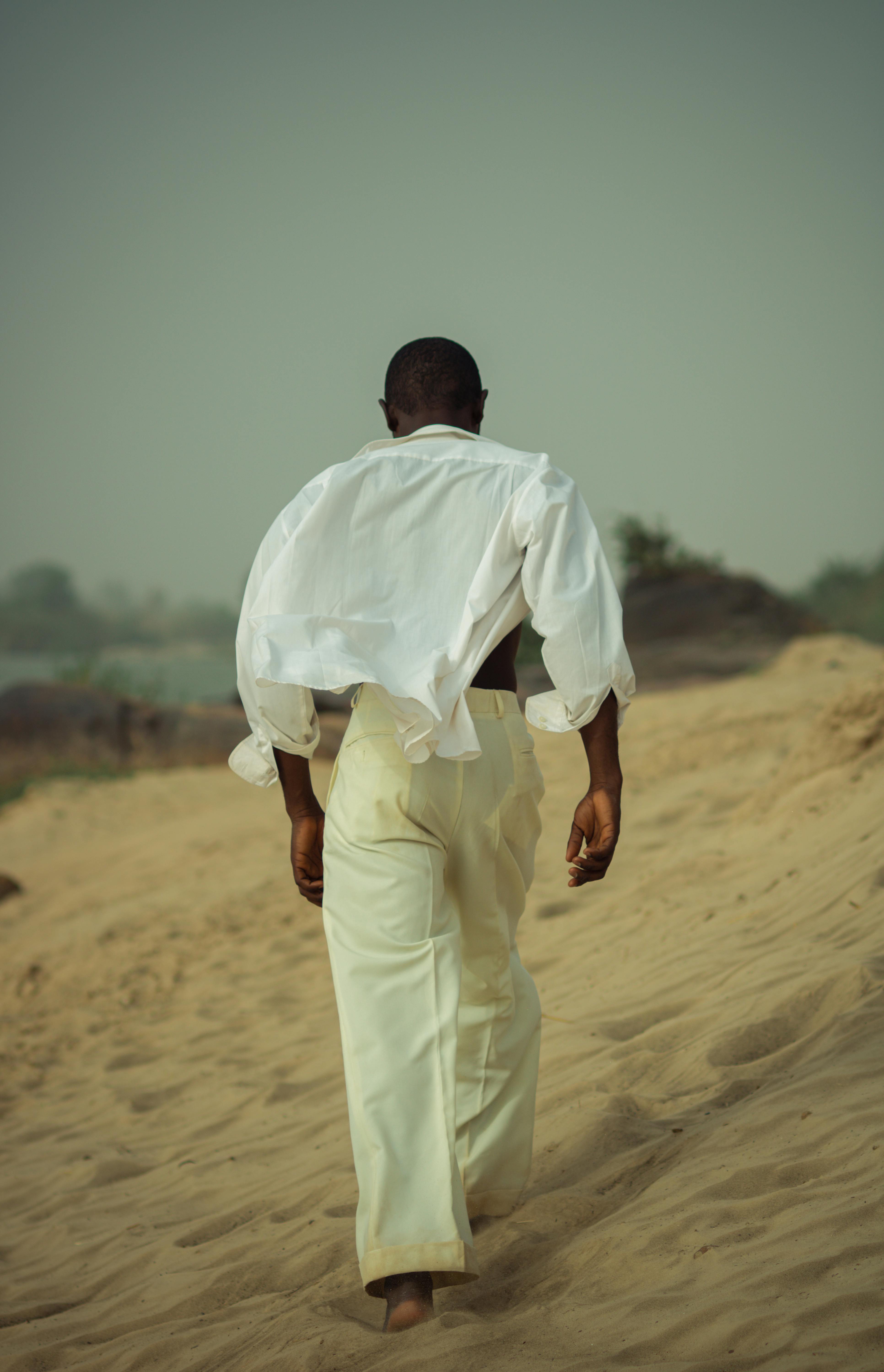 man walking through sand