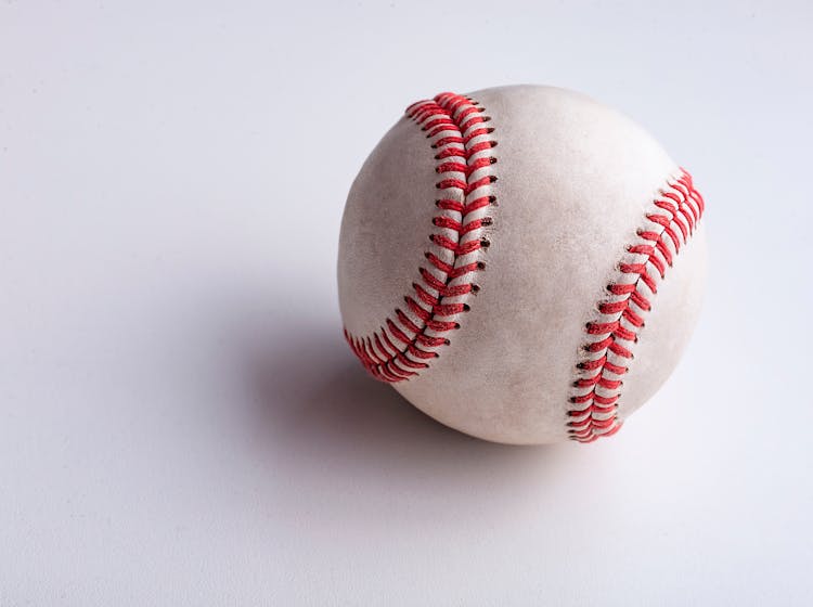 A Baseball On A White Surface