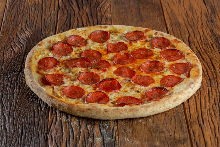 A Pepperoni Pizza On A Wooden Surface 