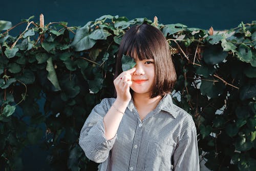 Free Woman Holding Leaf Covering Her Right Eye Stock Photo