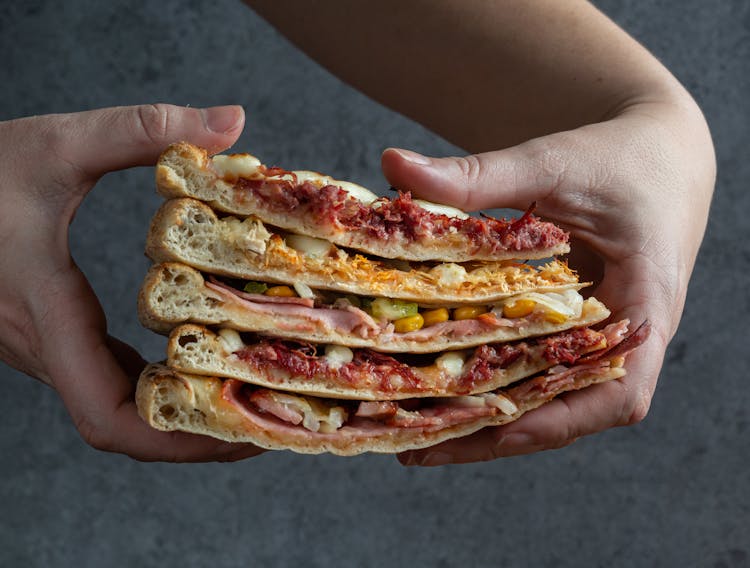 A Person Holding Pizza Slices