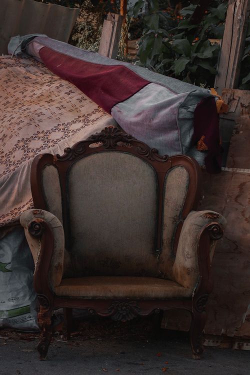 Free A weathered vintage armchair amidst debris, capturing rustic charm and decay. Stock Photo