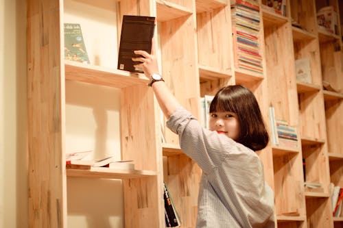 Mujer De Pie Junto A La Estantería De Libros