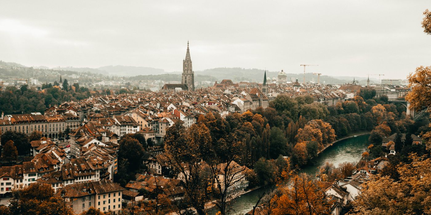 Aerial view of a European old town in autumn with a river and golden trees